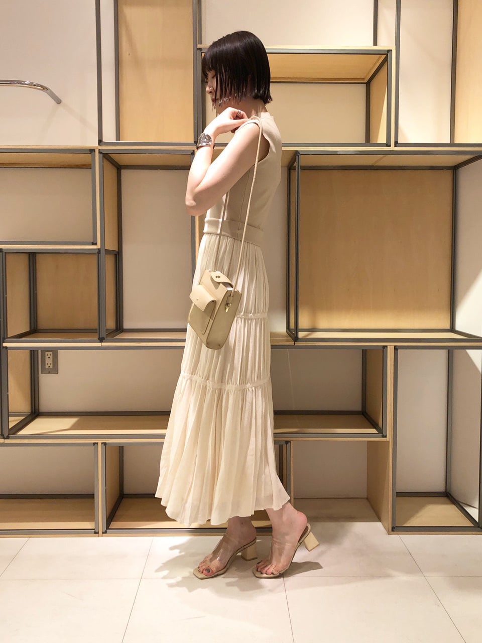 ベージュ系のハンドバッグ、ベージュ系のブルゾン、ベージュ系のワンピースを着用したレディースの春コーディネートの2枚目の写真