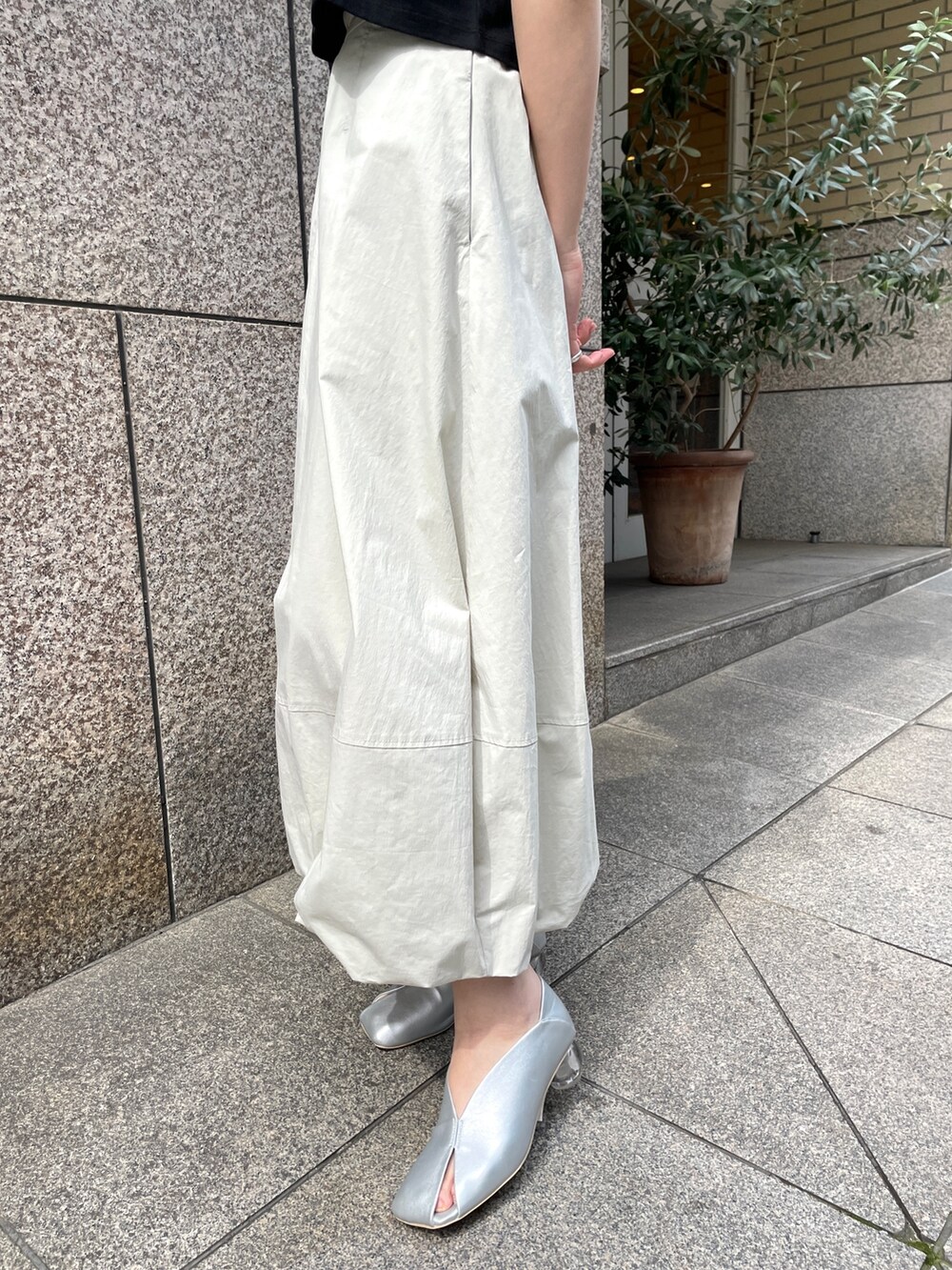シルバー系のパンプス、ブラック系のTシャツ/カットソー、ホワイト系のスカートを着用したレディースの春コーディネートの8枚目の写真