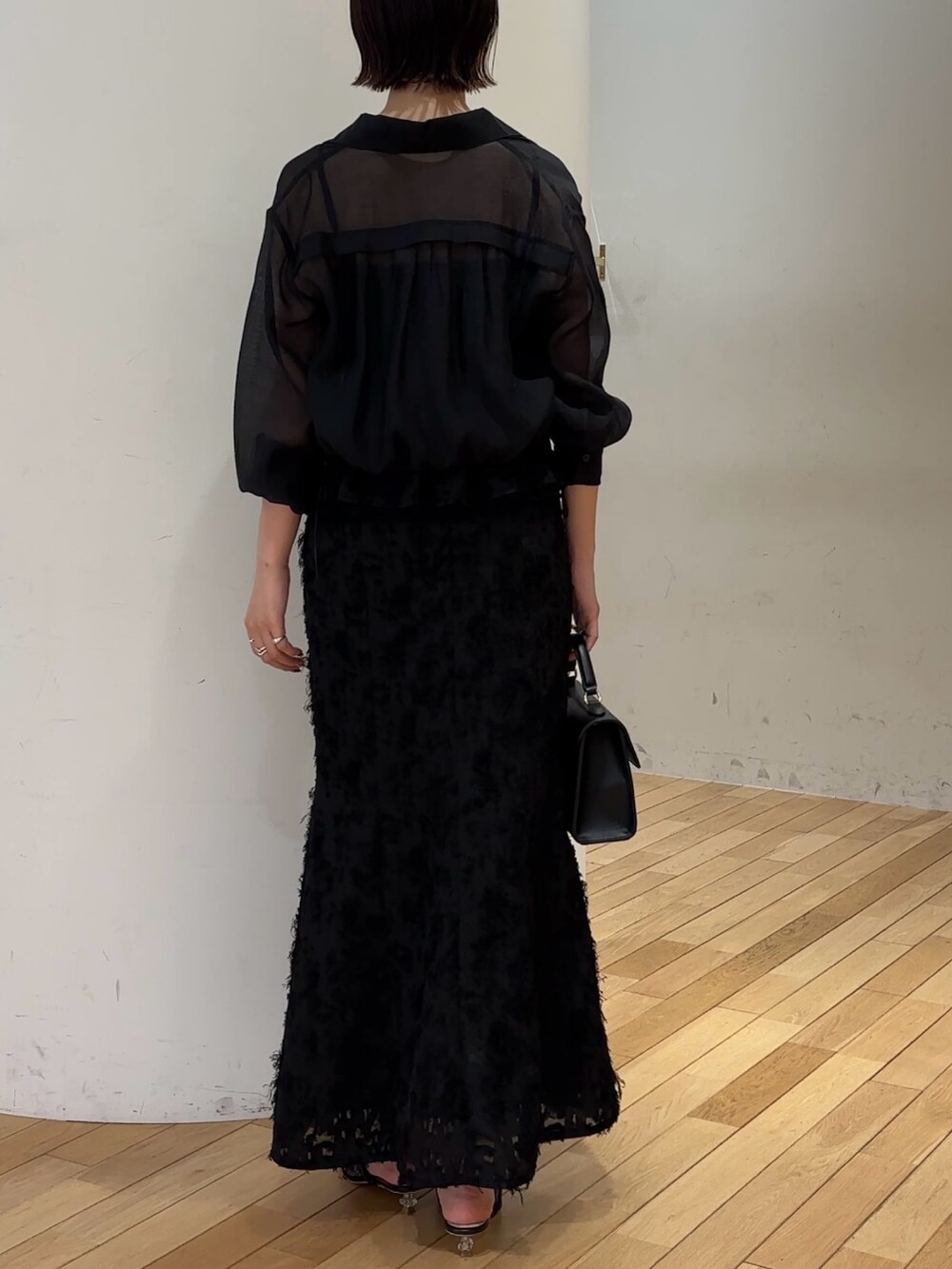 ブラック系のハンドバッグ、ブラック系のスカート、ブラック系のシャツ/ブラウスを着用したレディースの夏コーディネートの4枚目の写真