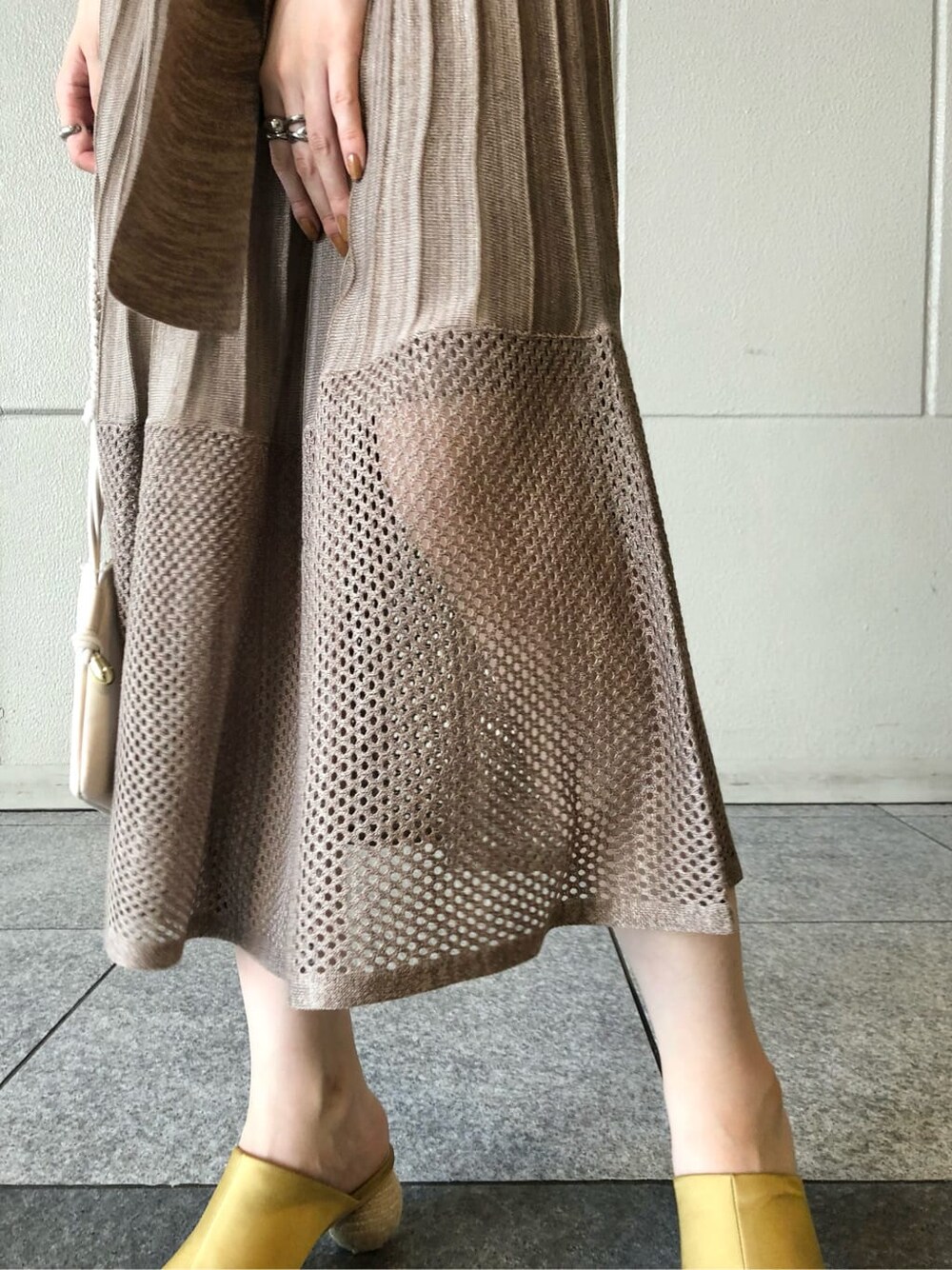 ホワイト系のショルダーバッグ、イエロー系のサンダル、ベージュ系のワンピースを着用したレディースの夏コーディネートの7枚目の写真