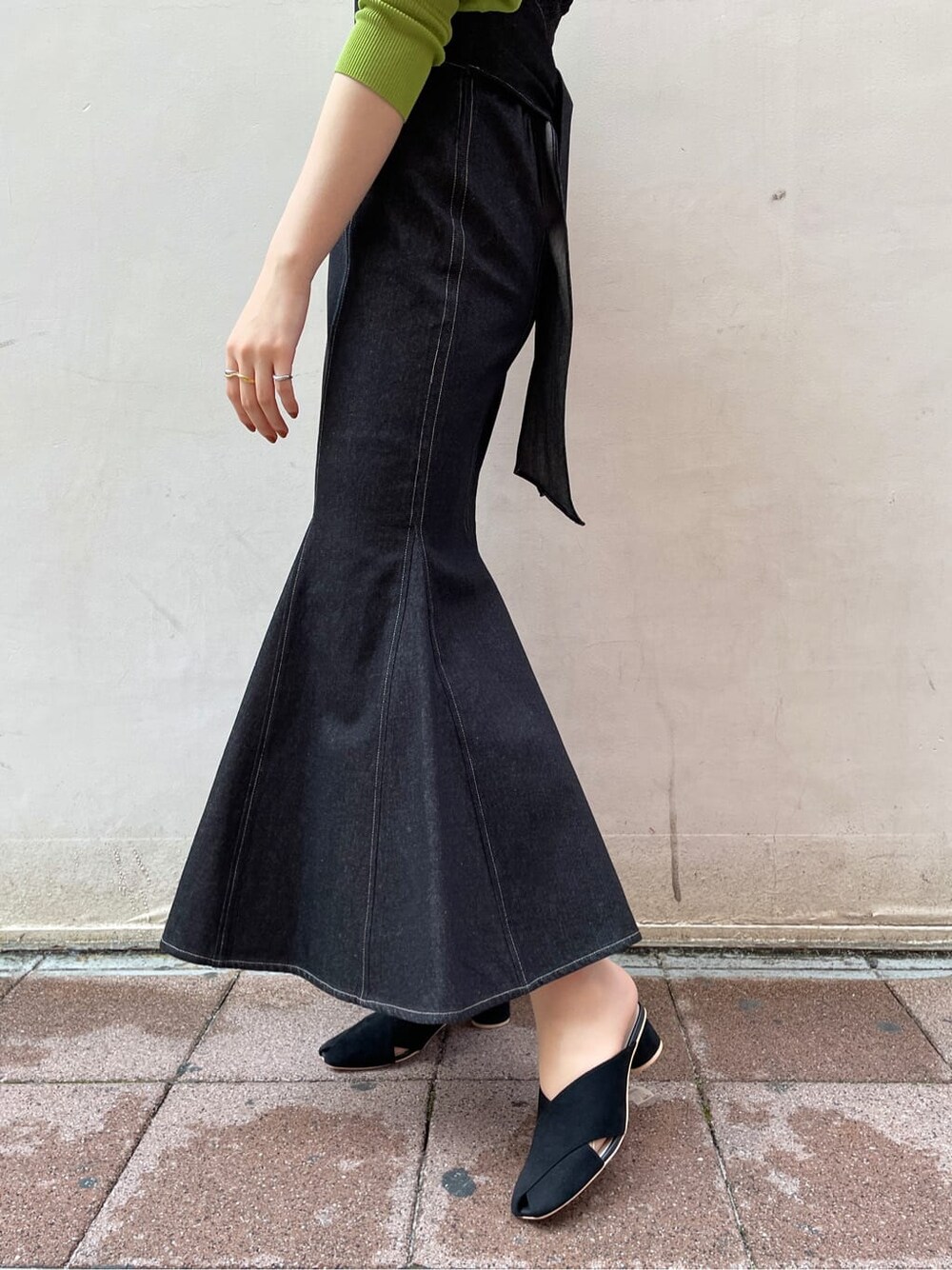 ブラック系のワンピース、グリーン系のニット/セーター、ブラック系のサンダルを着用したレディースの春コーディネートの4枚目の写真