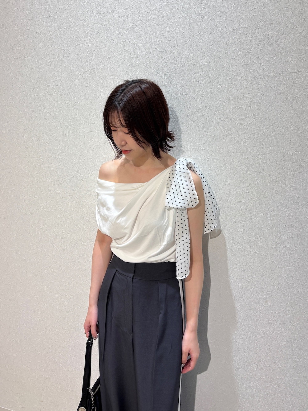 グレー系のその他パンツ、ホワイト系のサンダル、ブラック系のハンドバッグを着用したレディースの夏コーディネートの5枚目の写真