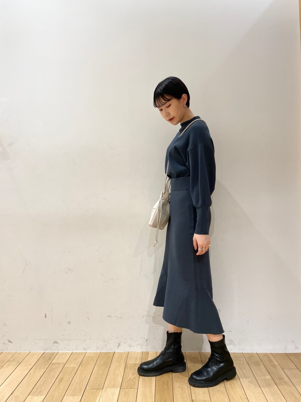 グリーン系のスカート、グリーン系のニット/セーター、ブラック系のブーツを着用したレディースの冬コーディネートの4枚目の写真