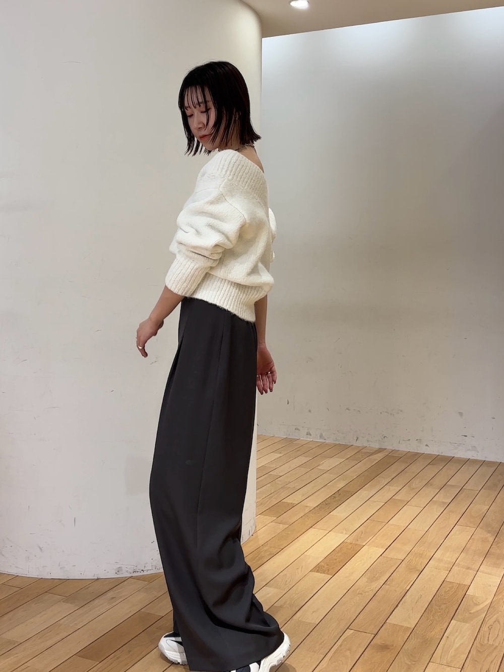 グレー系のその他パンツ、ホワイト系のニット/セーター、グレー系のスニーカーを着用したレディースの冬コーディネートの3枚目の写真