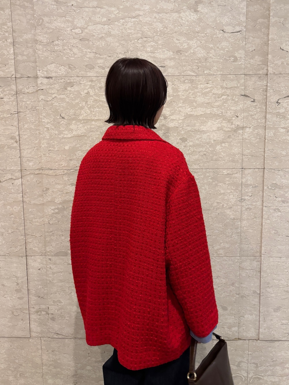 ブルー系のデニムパンツ、ブラウン系のニット/セーター、ブラウン系のハンドバッグを着用したレディースの冬コーディネートの5枚目の写真