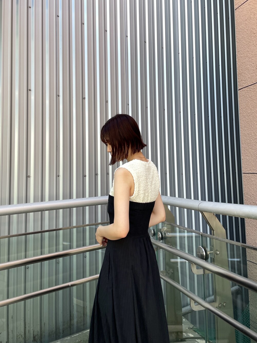 ブラック系のサンダル、ブラック系のワンピースを着用したレディースの夏コーディネートの6枚目の写真