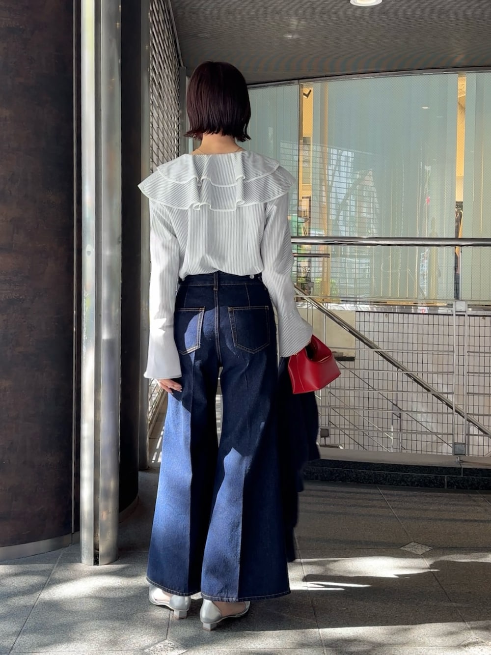 シルバー系のパンプス、ブルー系のカーディガン/ボレロ、ホワイト系のシャツ/ブラウスを着用したレディースの冬コーディネートの3枚目の写真