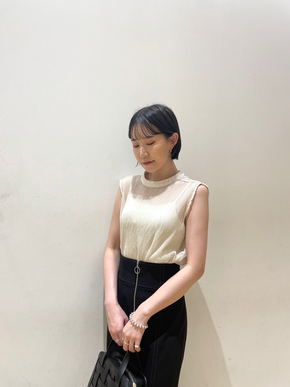 ホワイト系のシャツ/ブラウス、ブラック系のスカート、ブラック系のショルダーバッグを着用したレディースの夏コーディネートの7枚目の写真