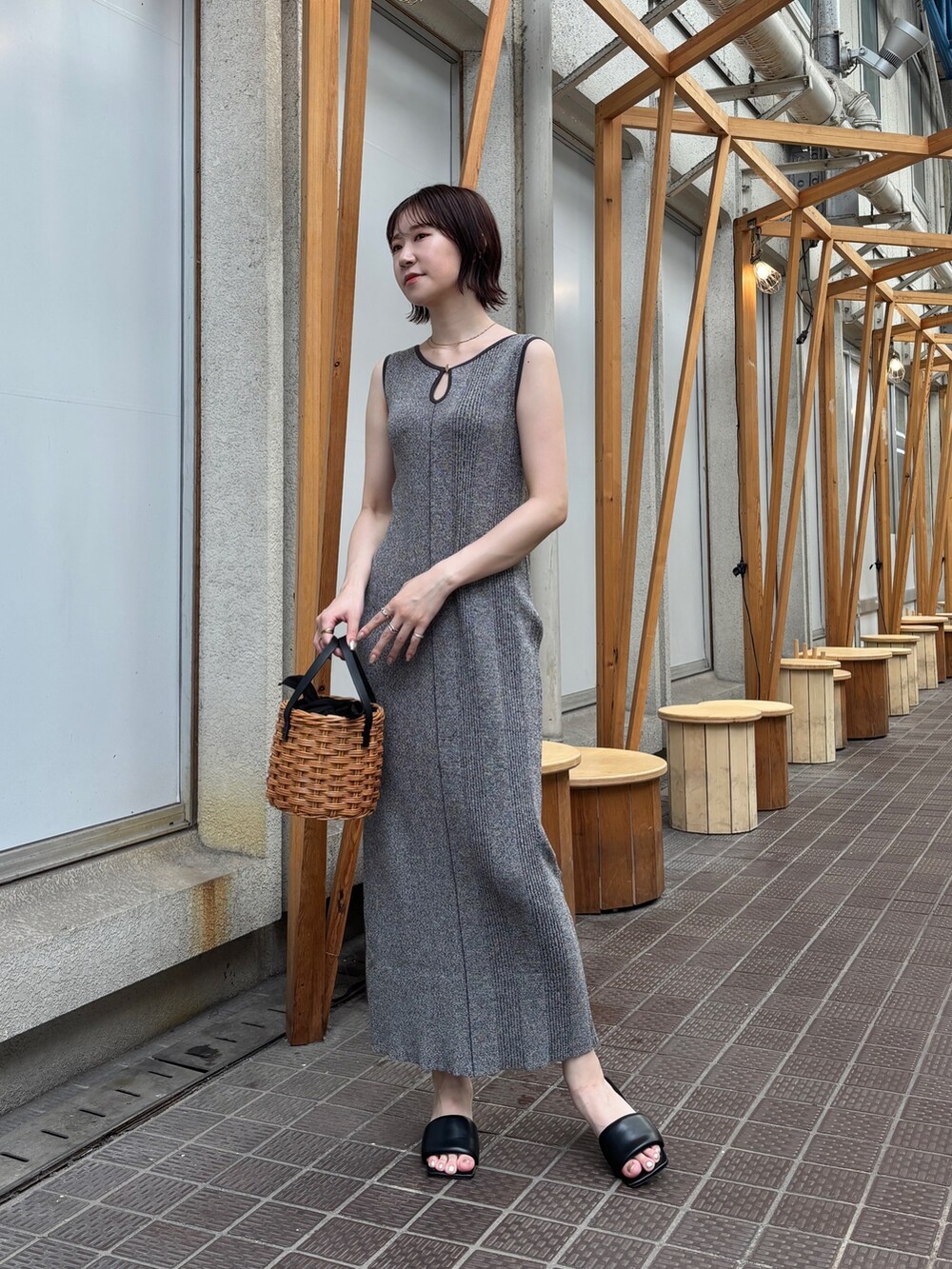 グレー系のワンピース、ブラウン系のハンドバッグを着用したレディースの夏コーディネートの3枚目の写真