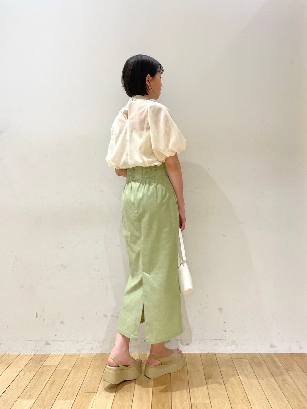 ベージュ系のサンダル、グリーン系のスカート、ホワイト系のシャツ/ブラウスを着用したレディースの夏コーディネートの5枚目の写真