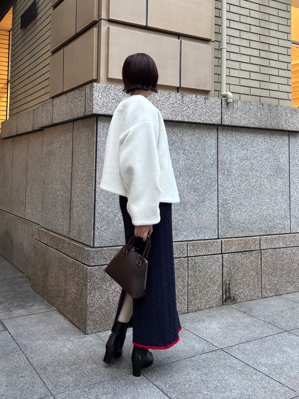 ホワイト系のブルゾン、ブルー系のワンピース、ブラウン系のボストンバッグを着用したレディースの秋コーディネートの5枚目の写真