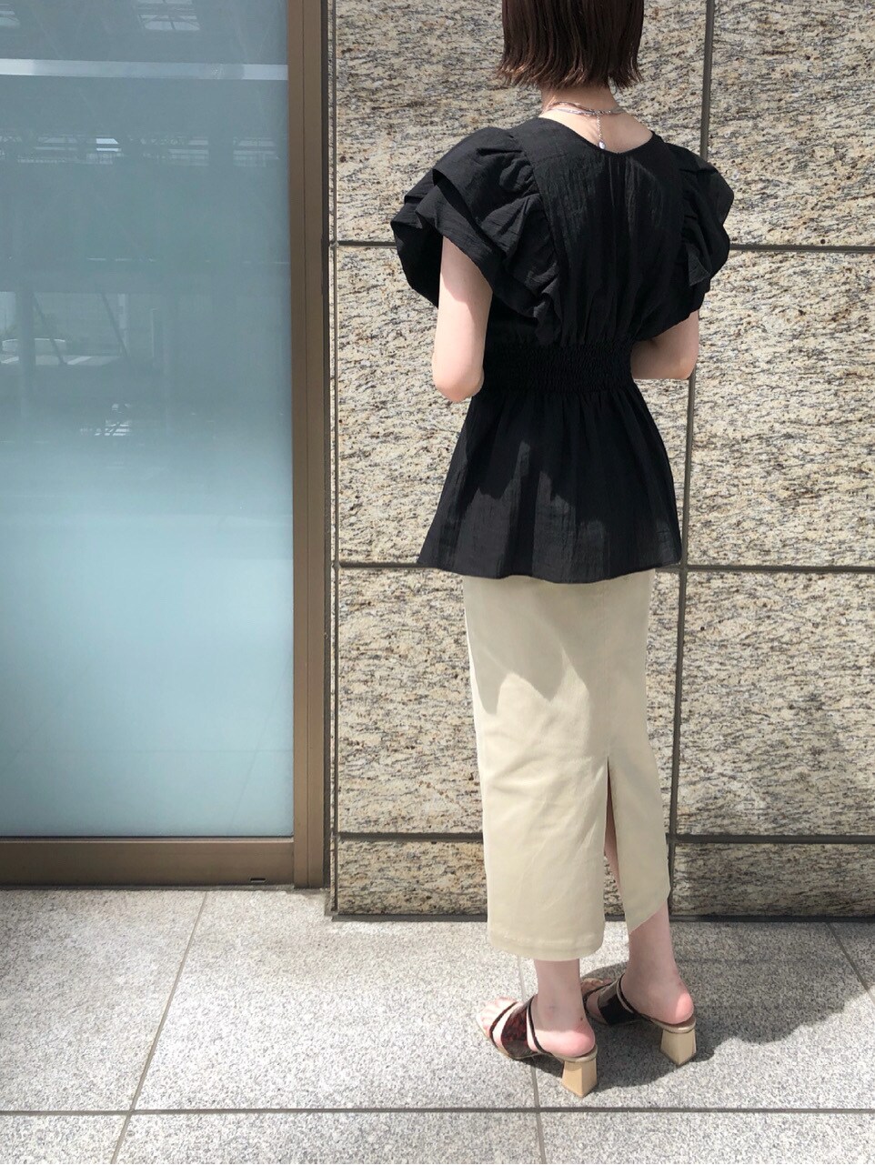 ブラック系のシャツ/ブラウス、ベージュ系のスカート、その他のその他シューズを着用したレディースの春コーディネートの6枚目の写真