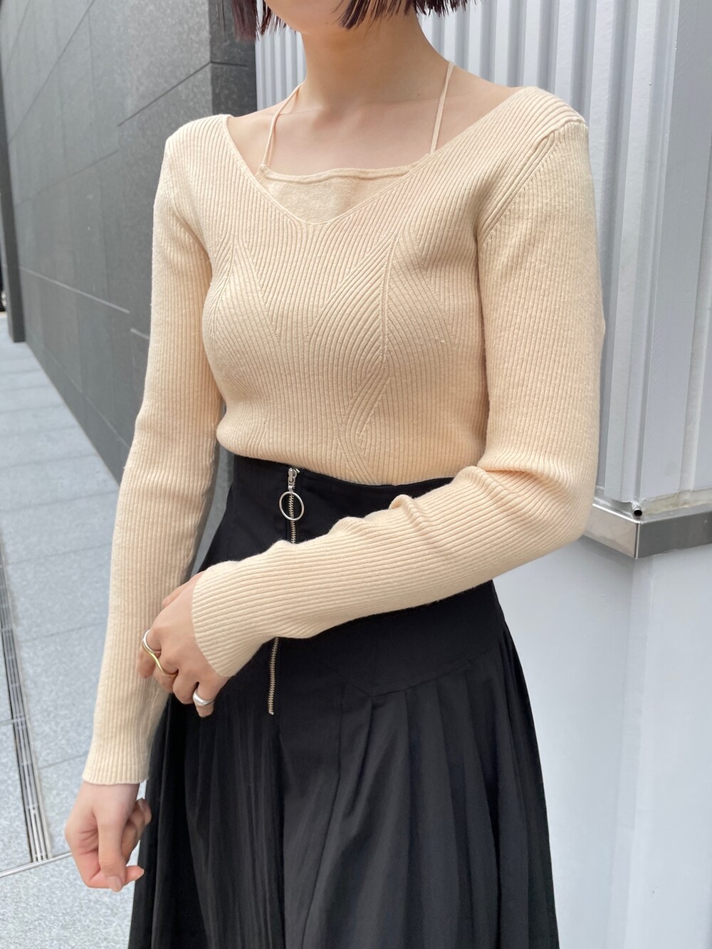 ブラック系のブーツ、ホワイト系のニット/セーター、ブラック系のスカートを着用したレディースの冬コーディネートの7枚目の写真