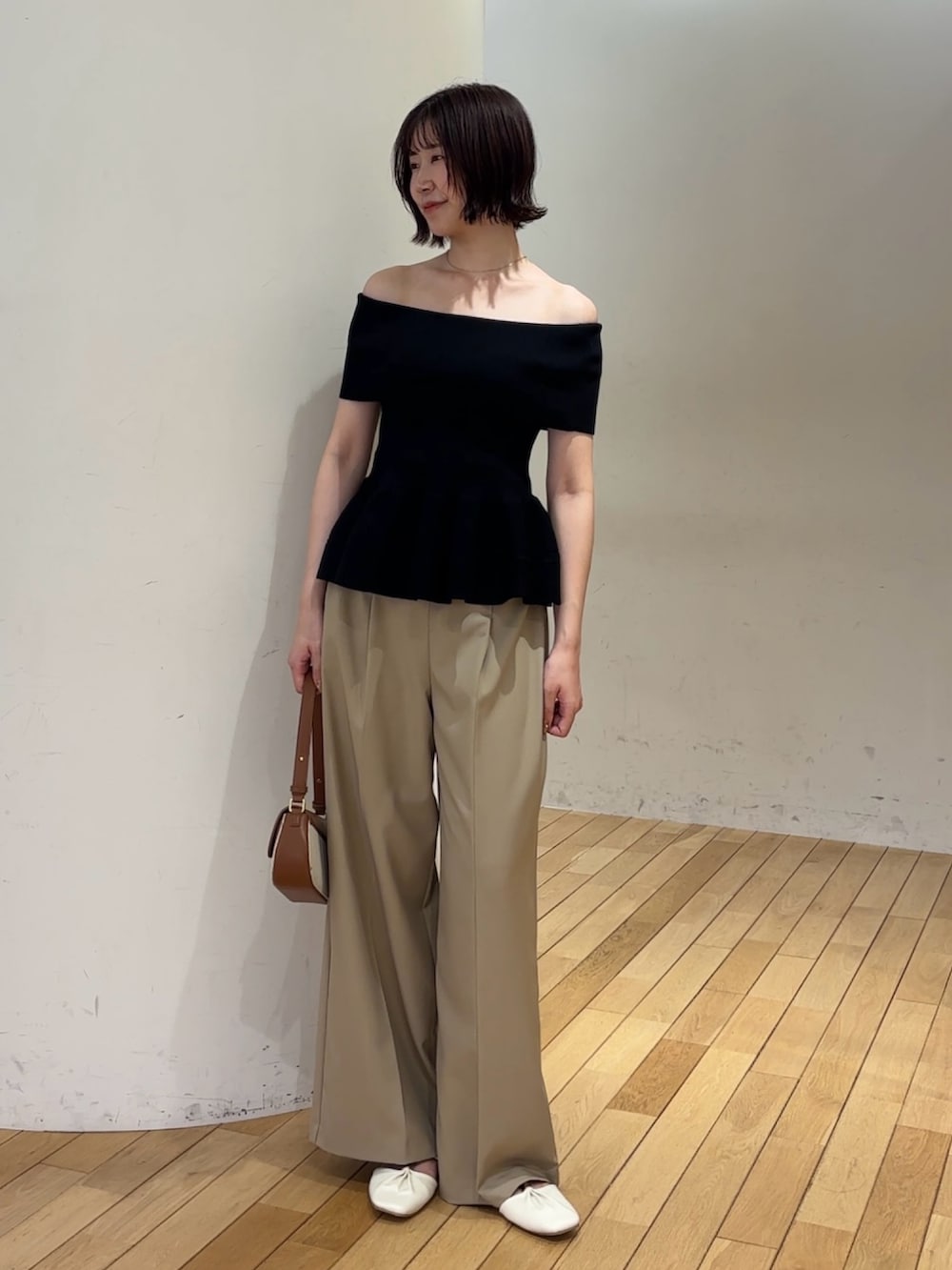 ベージュ系のその他パンツ、ホワイト系のサンダル、ブラウン系のハンドバッグを着用したレディースの夏コーディネートの2枚目の写真