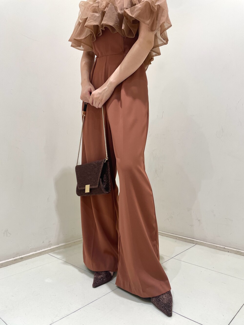 オレンジ系のパンツドレス、その他のクラッチバッグ、その他のパンプスを着用したレディースの夏コーディネートの8枚目の写真