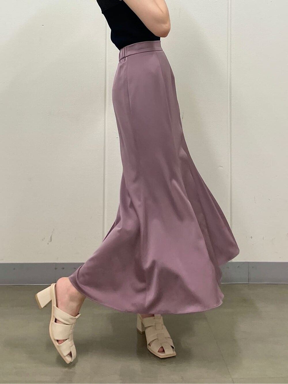 ピンク系のスカート、ホワイト系のサンダル、ブラック系のニット/セーターを着用したレディースの夏コーディネートの4枚目の写真