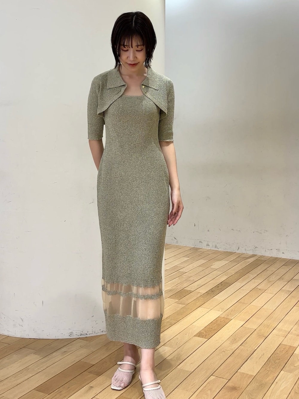 ベージュ系のワンピース、ブラウン系のハンドバッグ、ホワイト系のサンダルを着用したレディースの春コーディネートの4枚目の写真