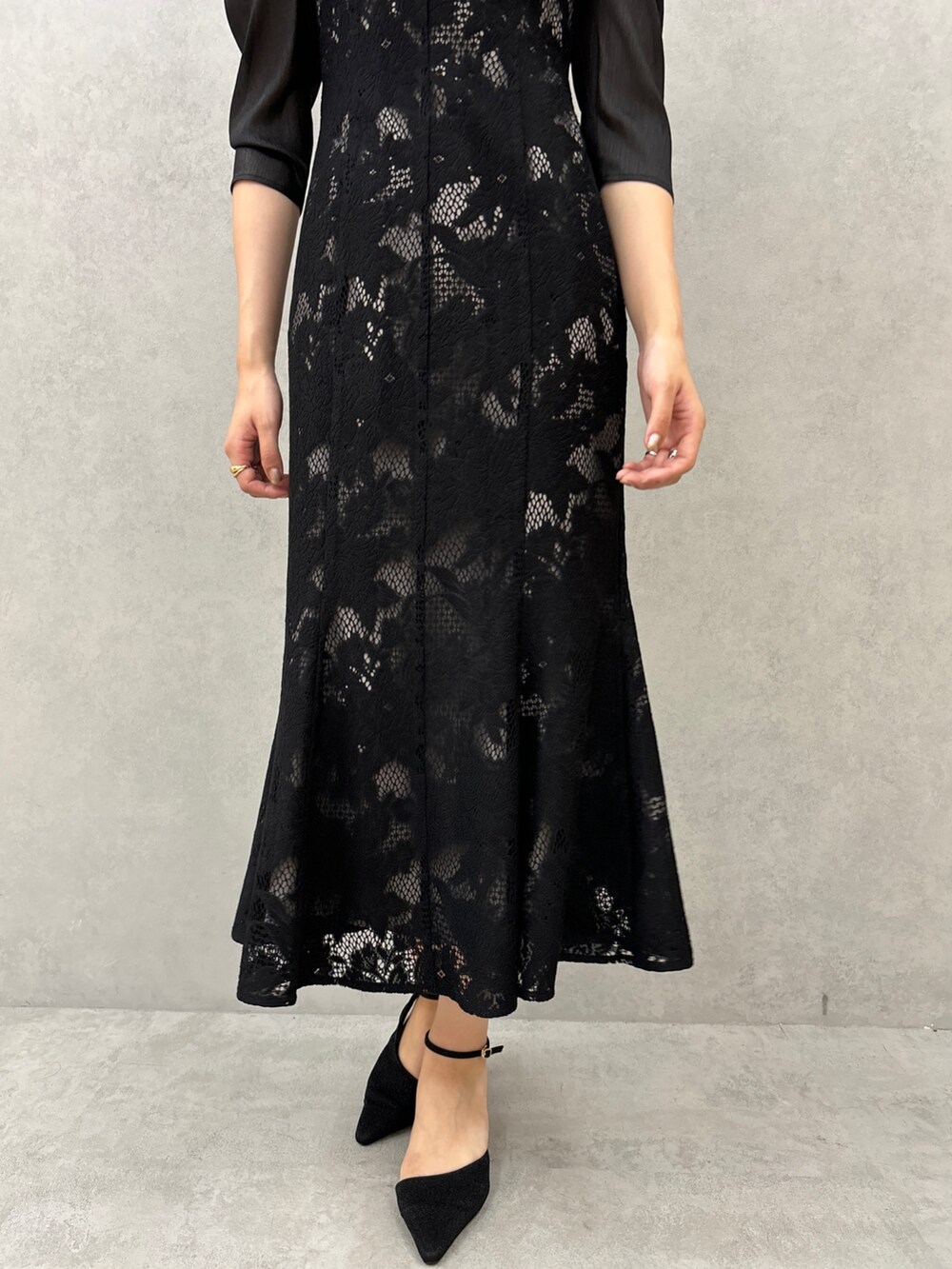 ブラック系のドレス、ブラック系のパンプスを着用したレディースの秋コーディネートの7枚目の写真