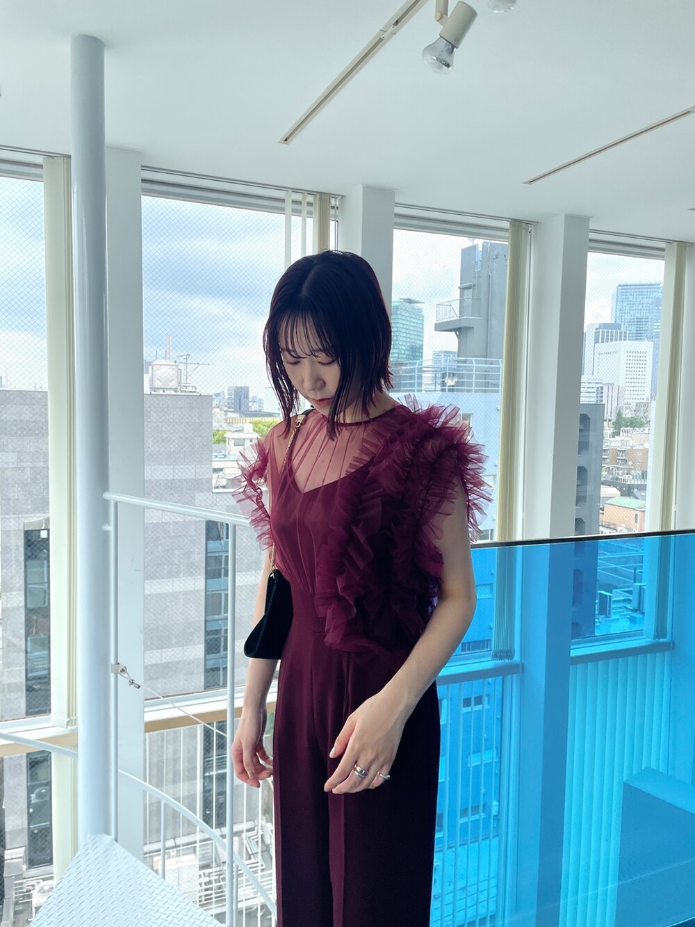 レッド系のパンツドレスを着用したレディースの春コーディネートの6枚目の写真