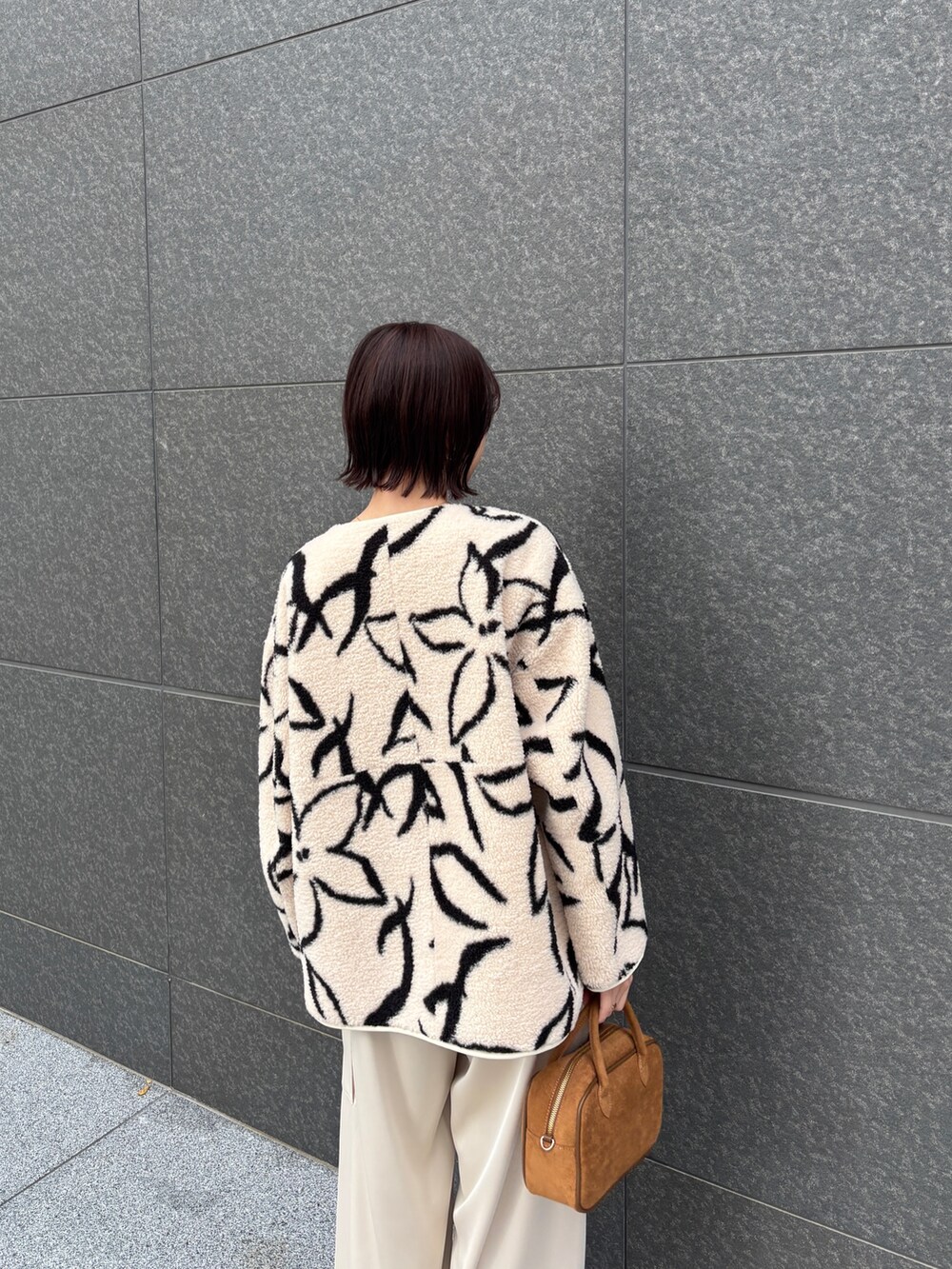 ホワイト系のブルゾン、ホワイト系のニット/セーター、ホワイト系のカーゴパンツを着用したレディースの冬コーディネートの5枚目の写真