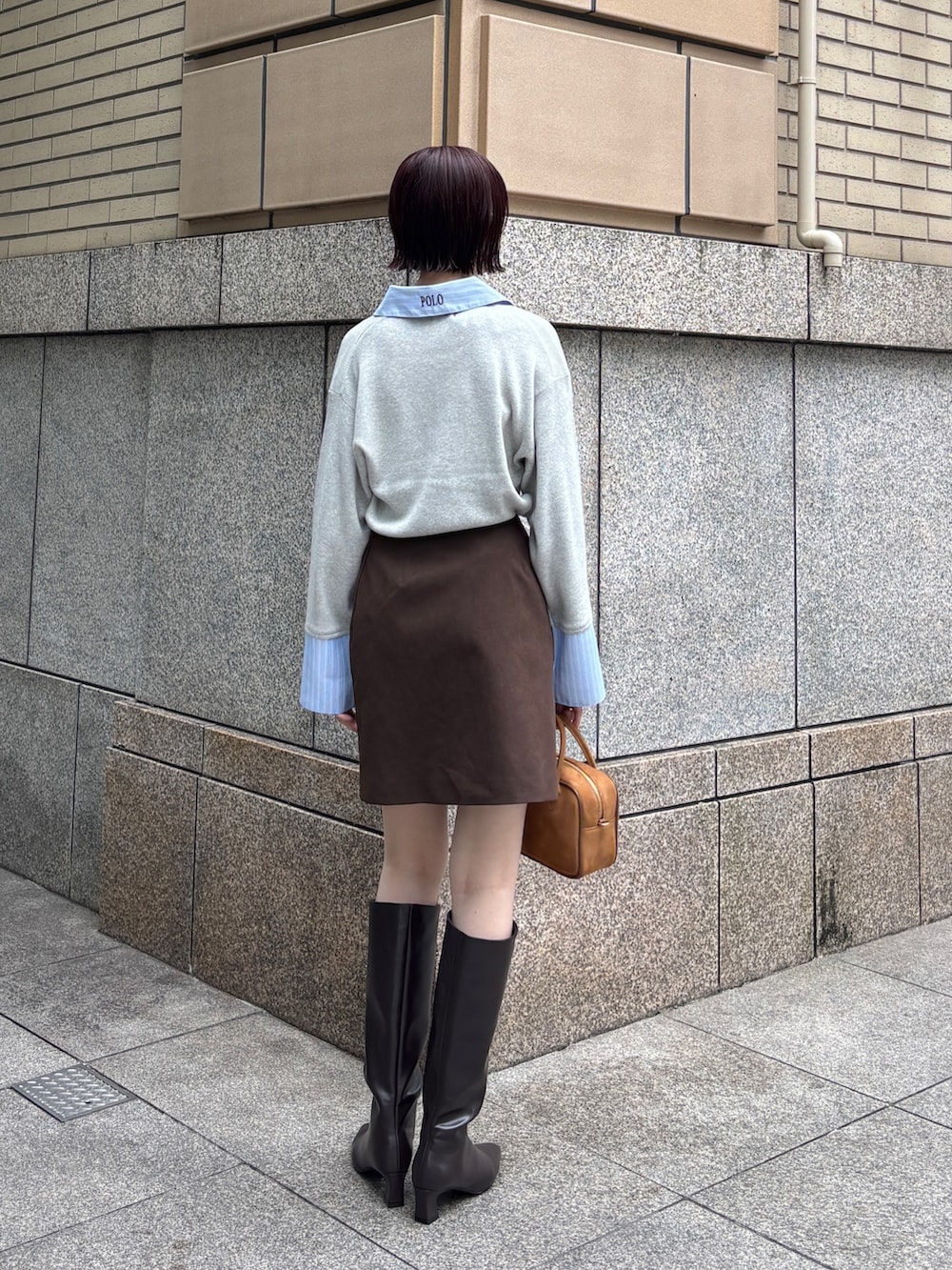 ブラウン系のスカート、グレー系のニット/セーター、イエロー系のハンドバッグを着用したレディースの秋コーディネートの3枚目の写真