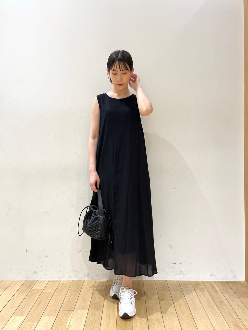 ブラック系のワンピース、ブラック系のハンドバッグ、ブラウン系のサンダルを着用したレディースの夏コーディネートの4枚目の写真