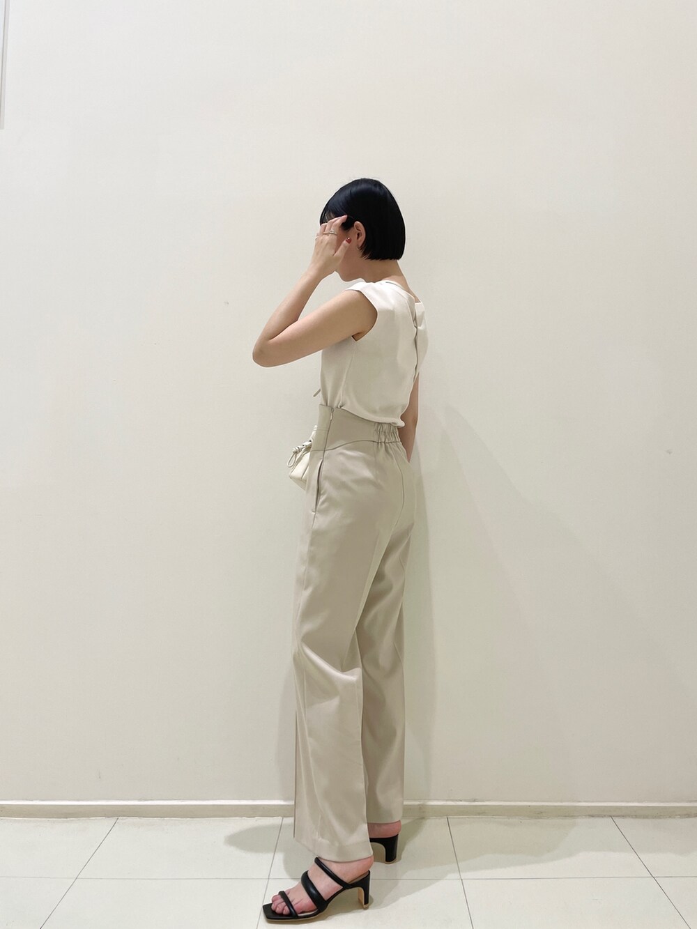 ブラック系のサンダル、ホワイト系のハンドバッグ、ホワイト系のその他パンツを着用したレディースの春コーディネートの4枚目の写真