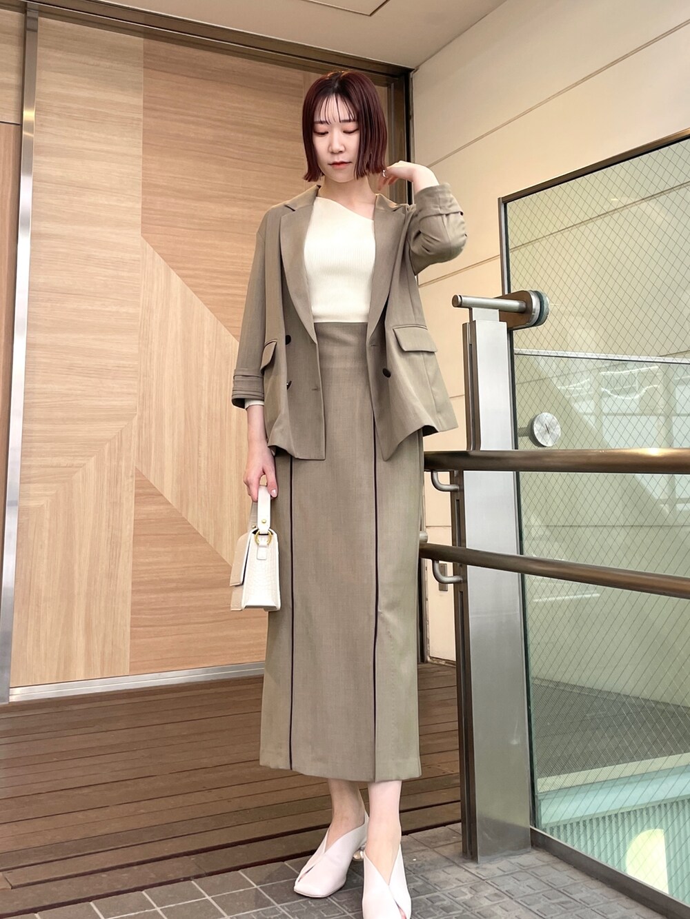 ホワイト系のパンプス、ホワイト系のニット/セーター、ブラウン系のスカートを着用したレディースの春コーディネートの7枚目の写真