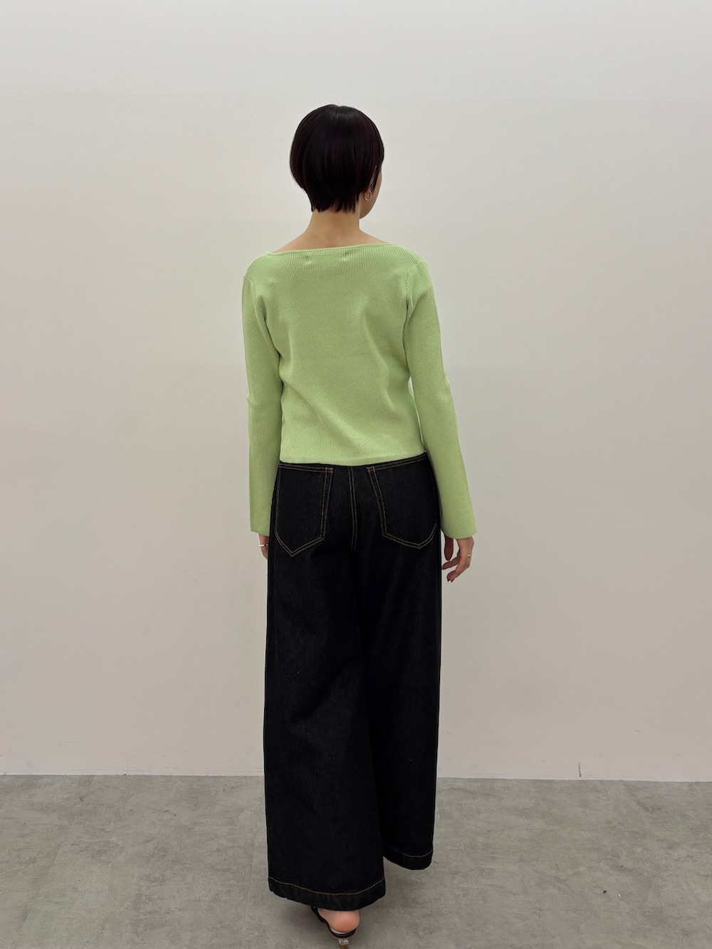 グリーン系のアンサンブル、ブラック系のデニムパンツ、ブラック系のサンダルを着用したレディースの春コーディネートの4枚目の写真