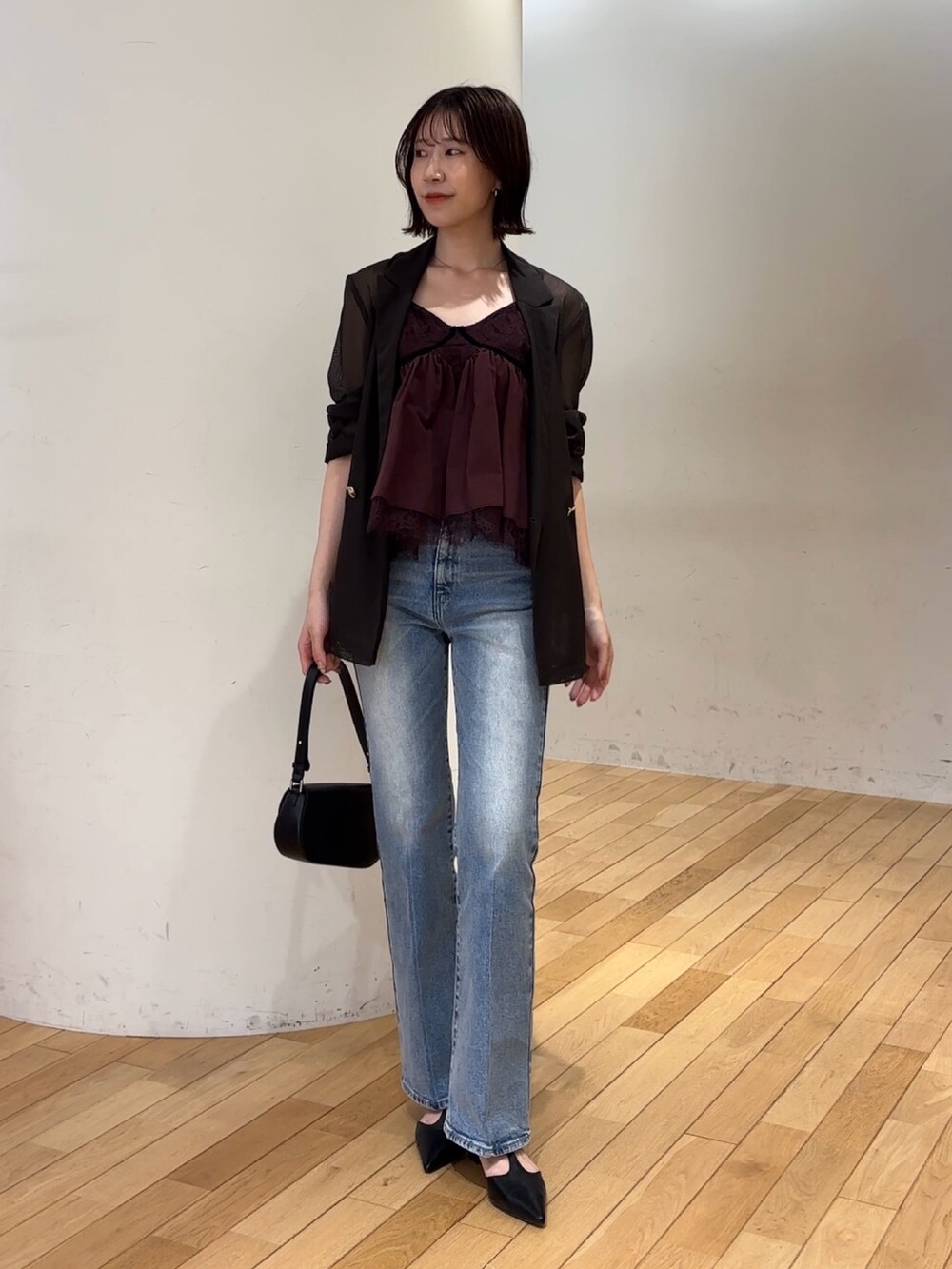 ブルー系のデニムパンツ、ブラック系のハンドバッグ、ブラック系のパンプスを着用したレディースの夏コーディネートの4枚目の写真