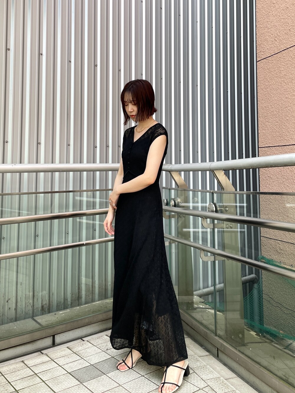 ブラック系のサンダル、ブラック系のワンピースを着用したレディースの夏コーディネートの5枚目の写真