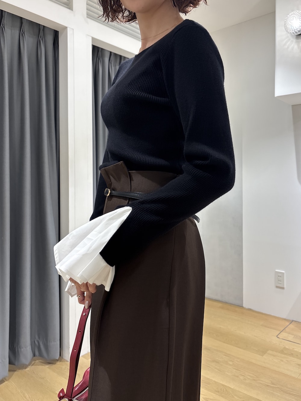 ブラック系のニット/セーター、ブラウン系のその他パンツ、レッド系のハンドバッグを着用したレディースの秋コーディネートの5枚目の写真