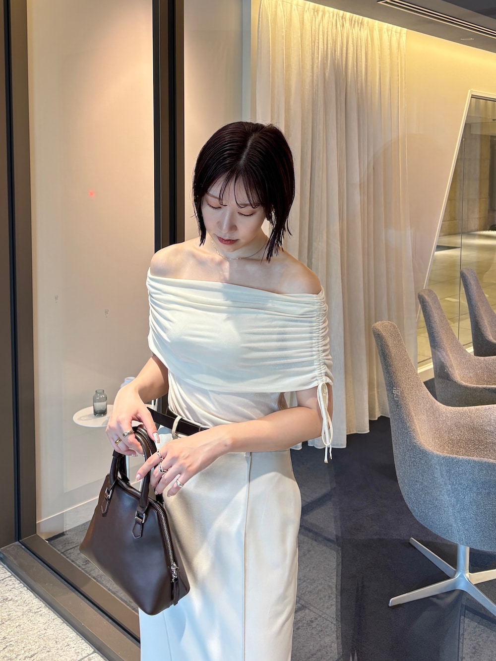 ホワイト系のスカート、ホワイト系のTシャツ/カットソー、ブラウン系のパンプスを着用したレディースの秋コーディネートの4枚目の写真