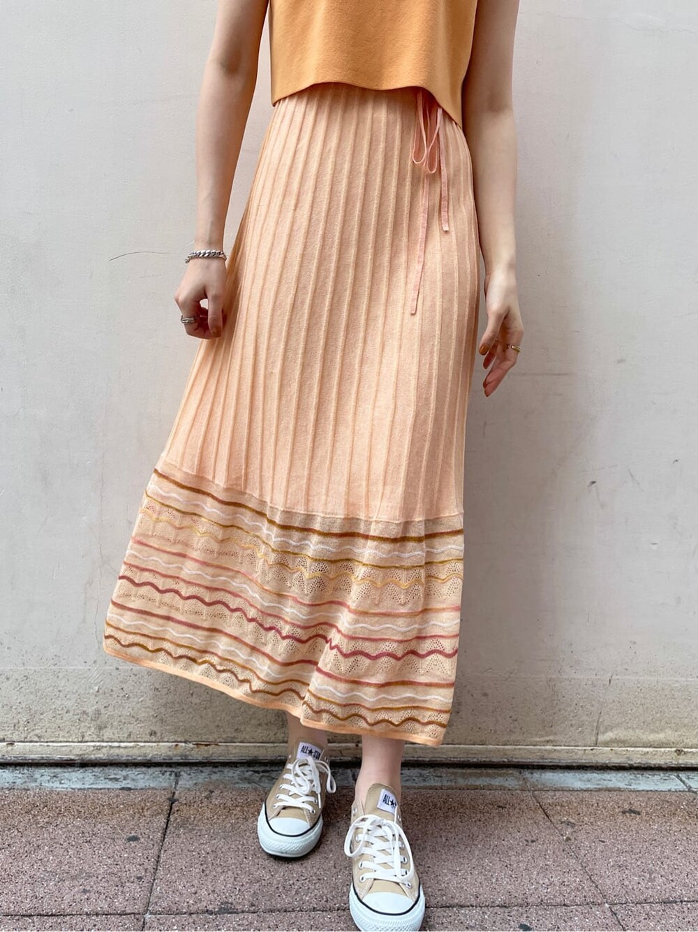 ホワイト系のテーラードジャケット、オレンジ系のワンピースを着用したレディースの春コーディネートの7枚目の写真