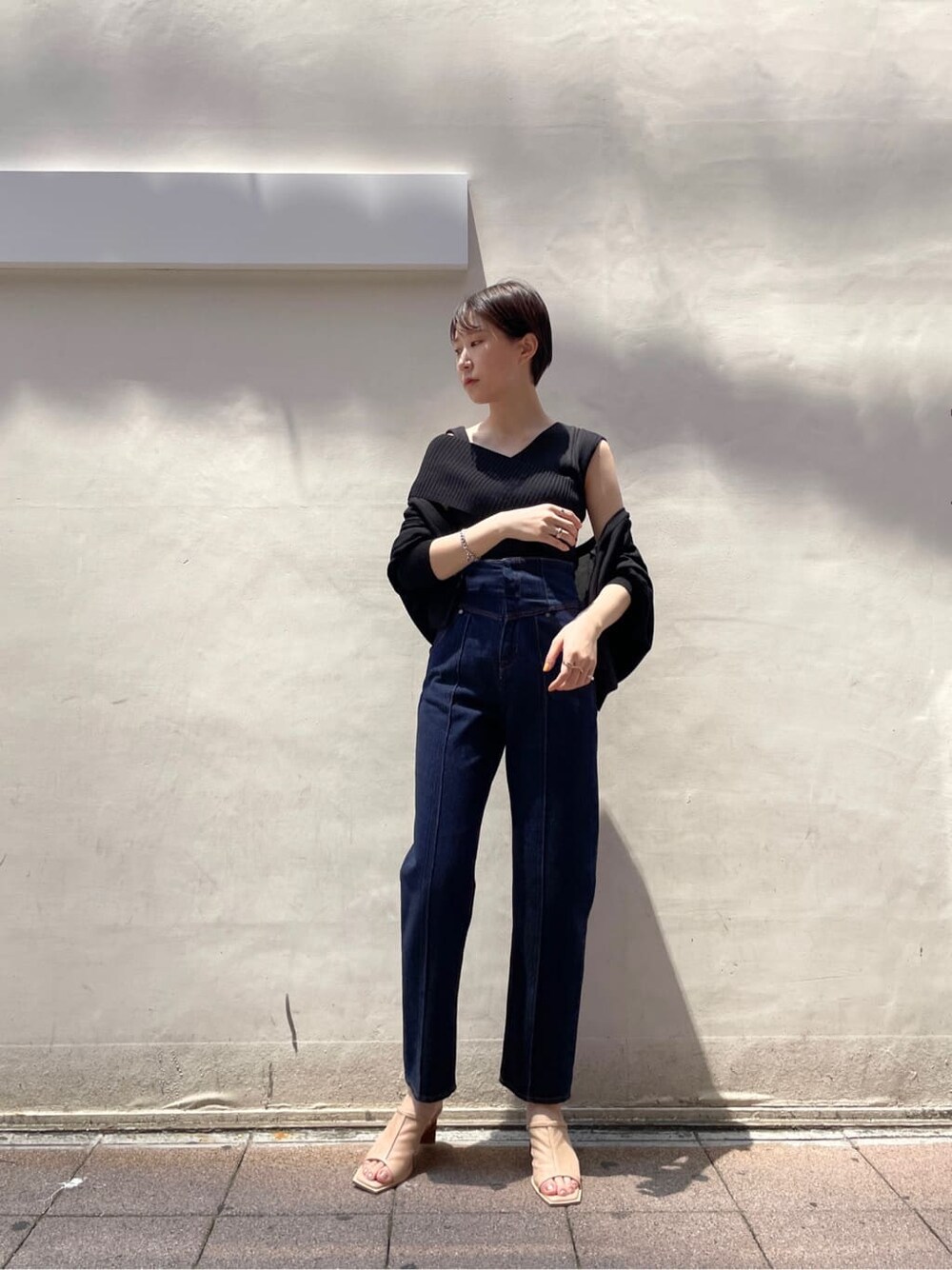 ブラック系のカーディガン/ボレロ、ベージュ系のサンダル、ブルー系のデニムパンツを着用したレディースの夏コーディネートの4枚目の写真