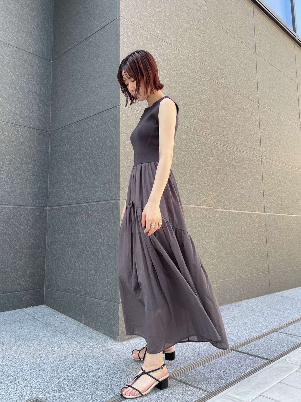 ブラック系のサンダル、グレー系のワンピース、ブラック系のショルダーバッグを着用したレディースの夏コーディネートの3枚目の写真