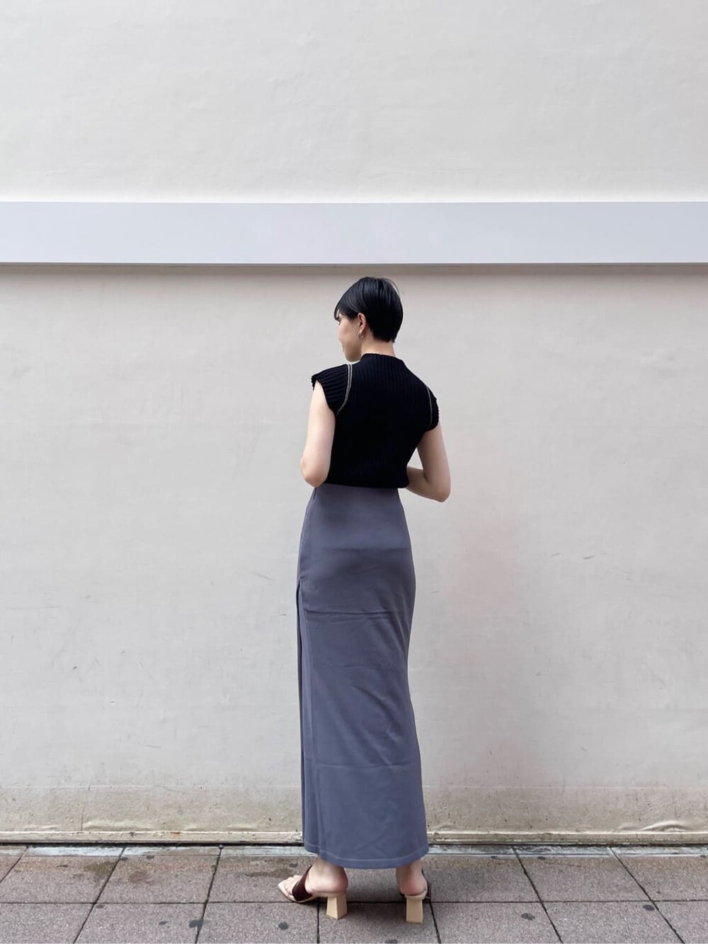 ホワイト系のサンダル、ブルー系のスカート、ブラック系のニット/セーターを着用したレディースの夏コーディネートの4枚目の写真