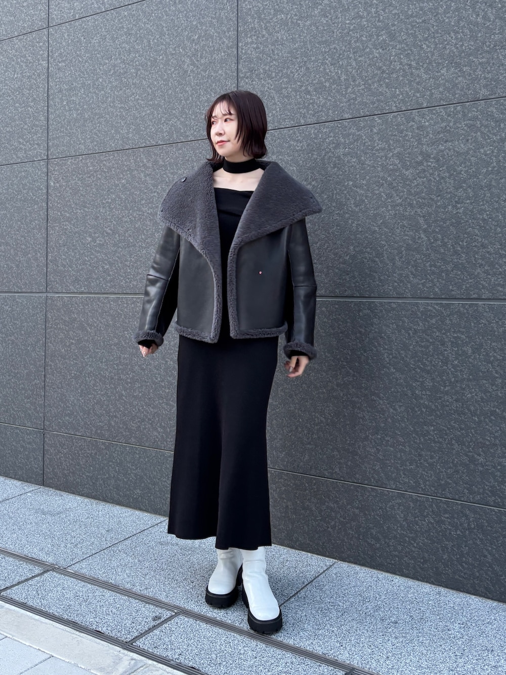 ブラック系のワンピース、グレー系のムートンコートを着用したレディースの冬コーディネートの5枚目の写真