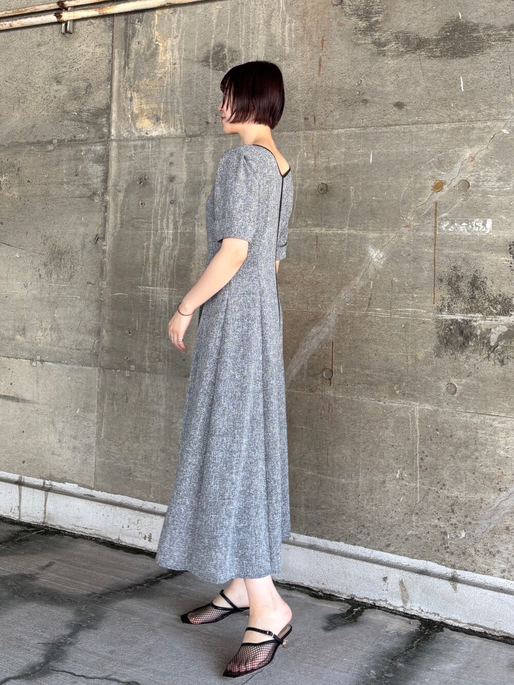 ブラック系のワンピース、イエロー系のハンドバッグ、ブラック系のサンダルを着用したレディースの夏コーディネートの3枚目の写真