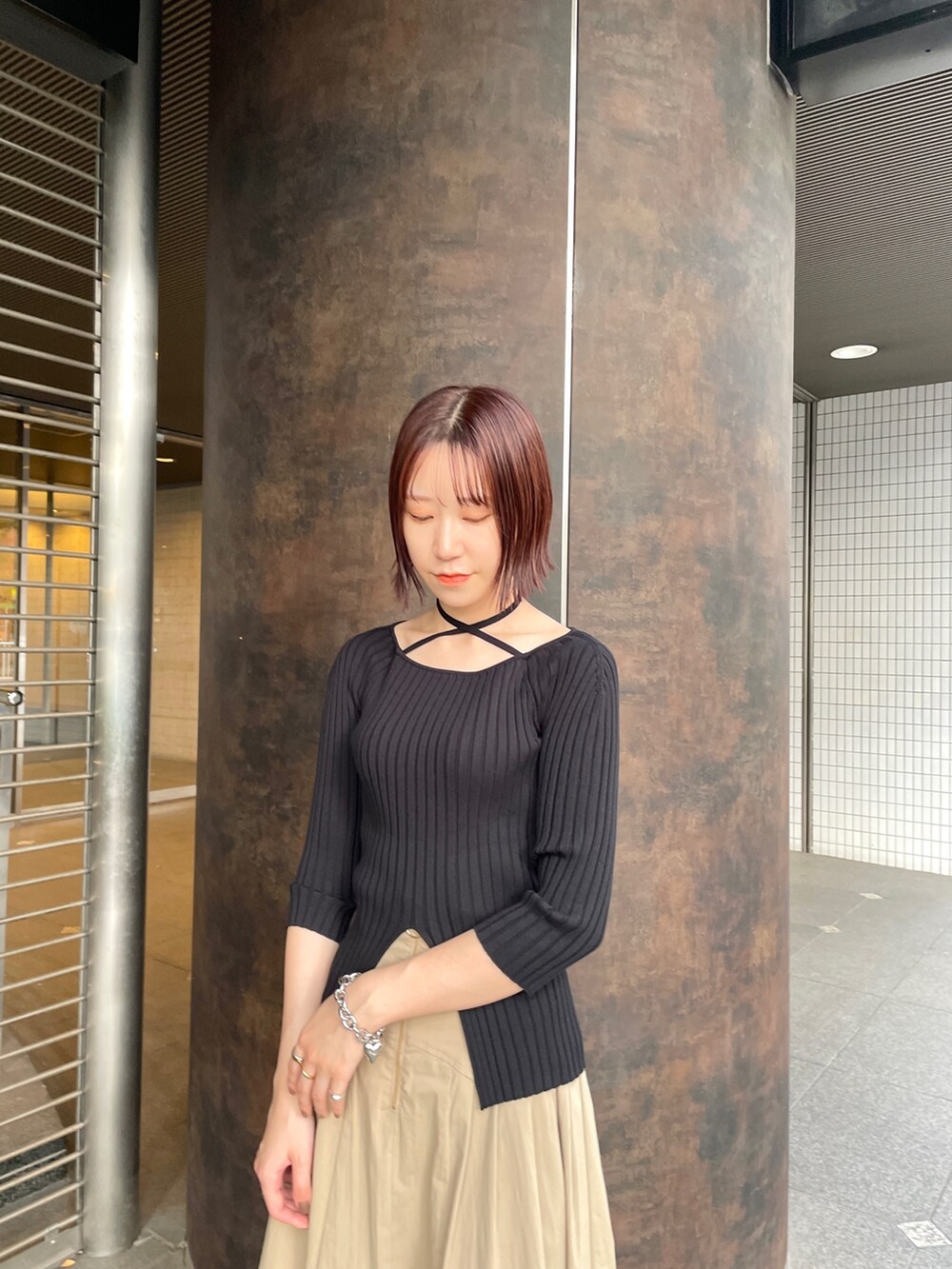 ブラック系のスニーカー、ブラック系のニット/セーター、ベージュ系のスカートを着用したレディースの春コーディネートの4枚目の写真