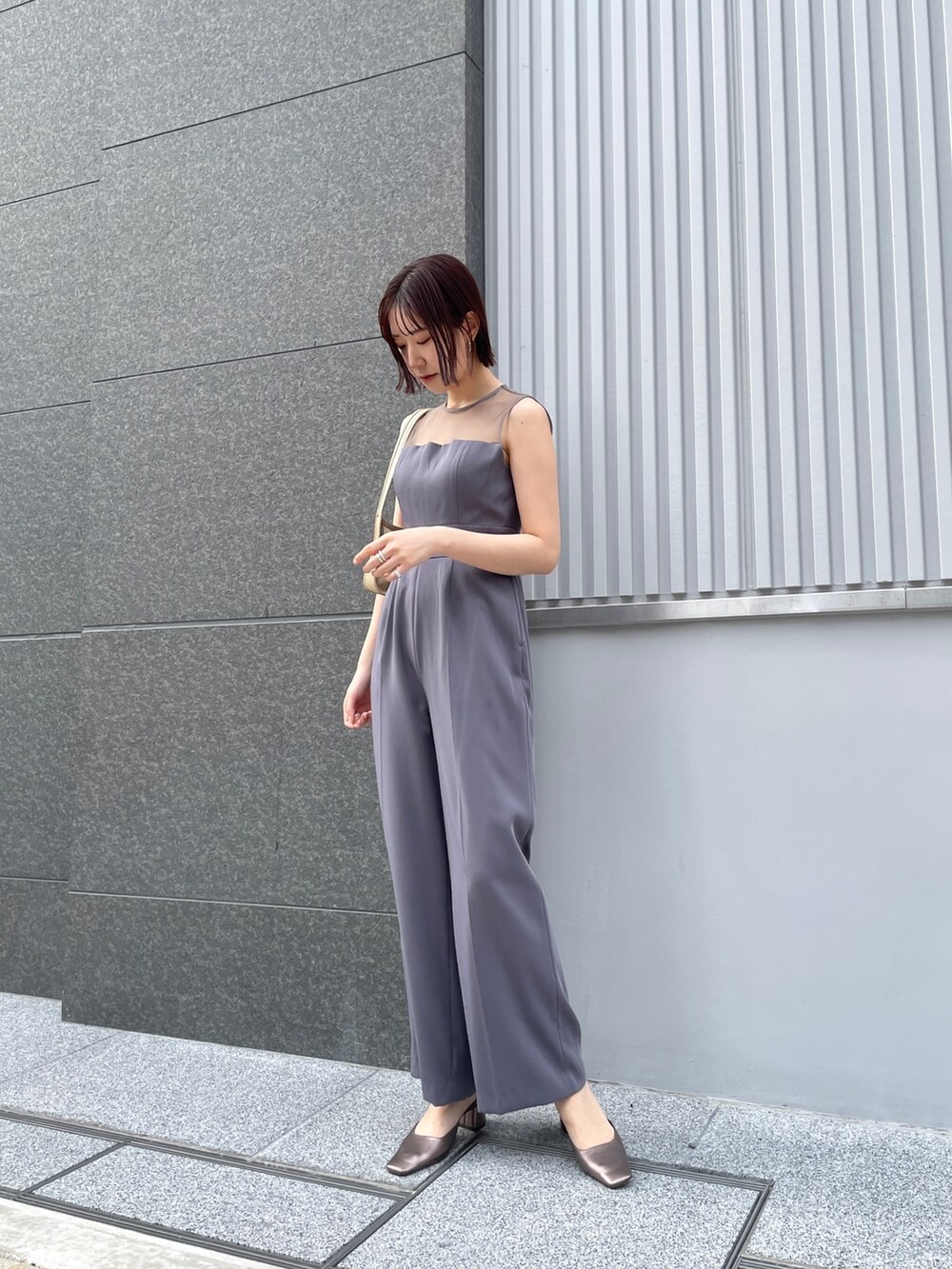 グレー系のパンツドレス、その他のパンプス、ベージュ系のテーラードジャケットを着用したレディースの春コーディネートの8枚目の写真