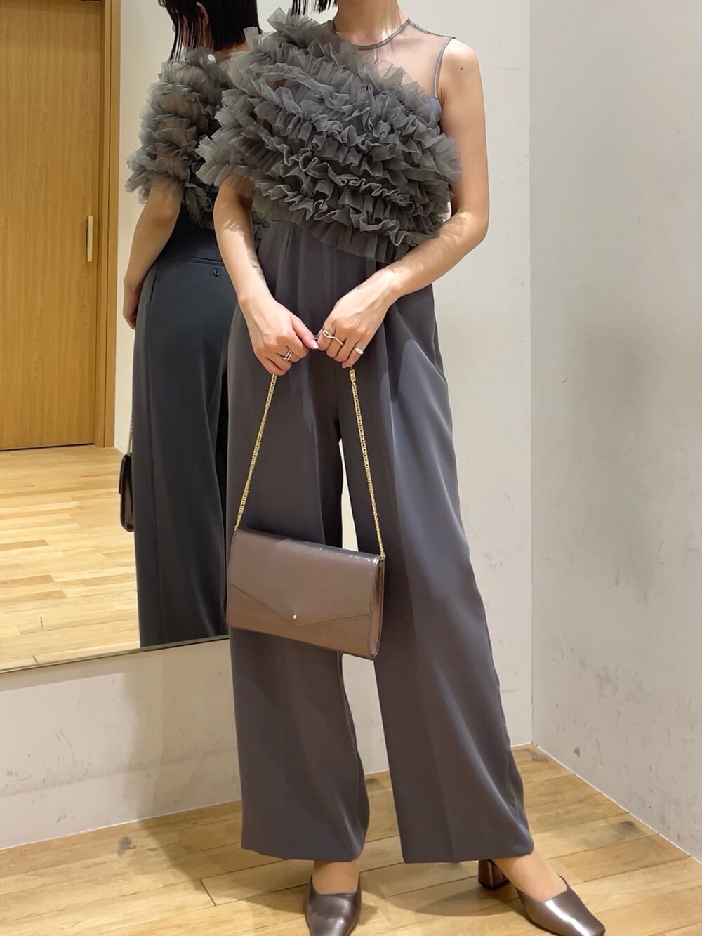 シルバー系のハンドバッグ、その他のパンプス、グレー系のパンツドレスを着用したレディースの冬コーディネートの4枚目の写真