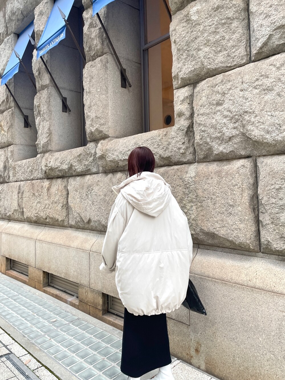 ホワイト系のダウンジャケット/コート、ブラック系のワンピースを着用したレディースの冬コーディネートの4枚目の写真