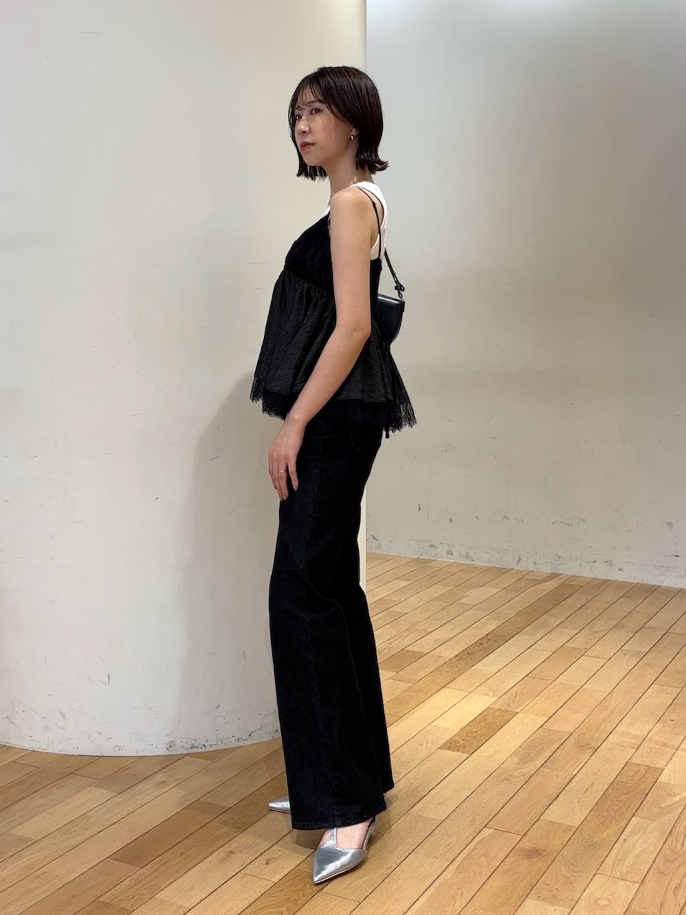 ブラック系のデニムパンツ、シルバー系のパンプス、ホワイト系のタンクトップを着用したレディースの夏コーディネートの2枚目の写真