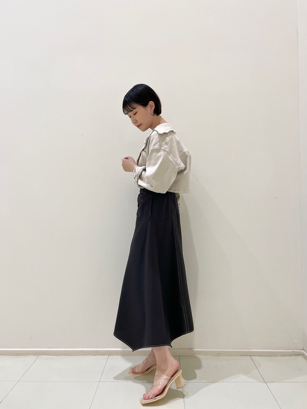 ブラック系のワンピース、その他のサンダル、ベージュ系のテーラードジャケットを着用したレディースの春コーディネートの2枚目の写真