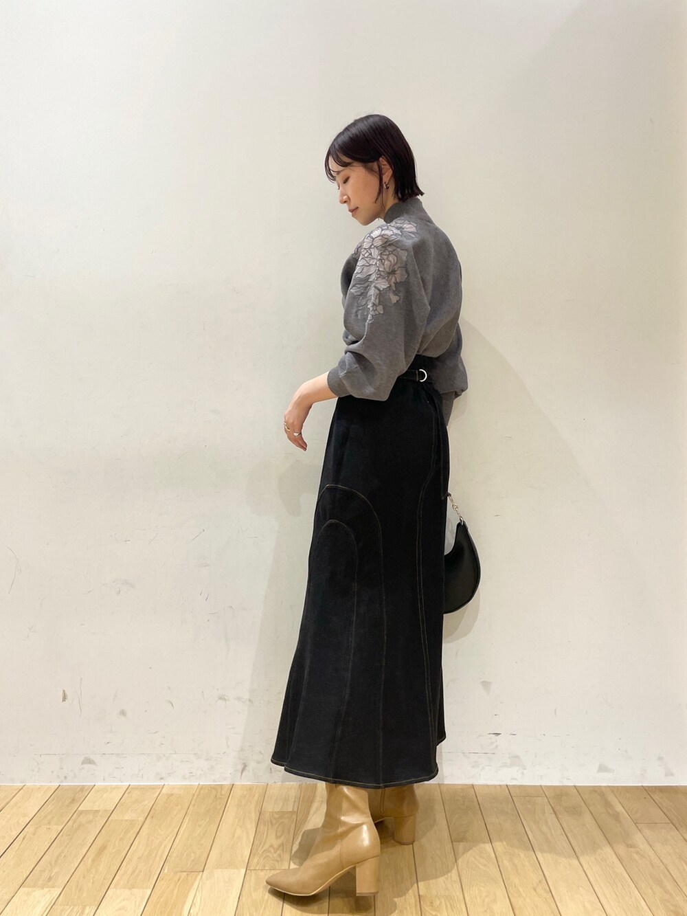 ベージュ系のブーツ、ブラック系のデニムスカート、ブラック系のハンドバッグを着用したレディースの夏コーディネートの4枚目の写真