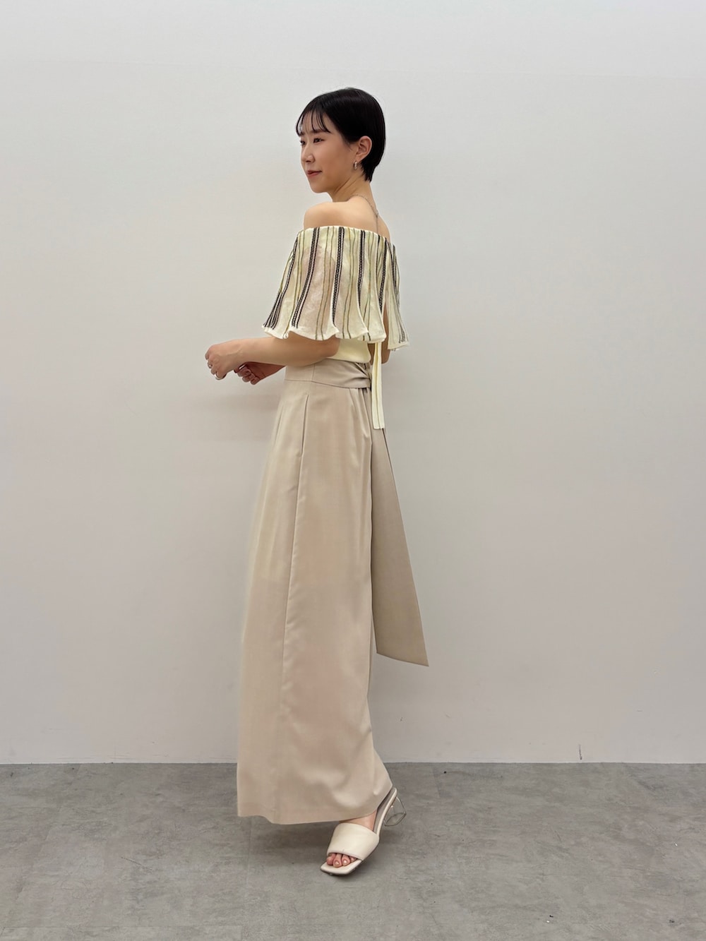 ホワイト系のニット/セーター、ベージュ系のその他パンツ、ホワイト系のサンダルを着用したレディースの春コーディネートの3枚目の写真