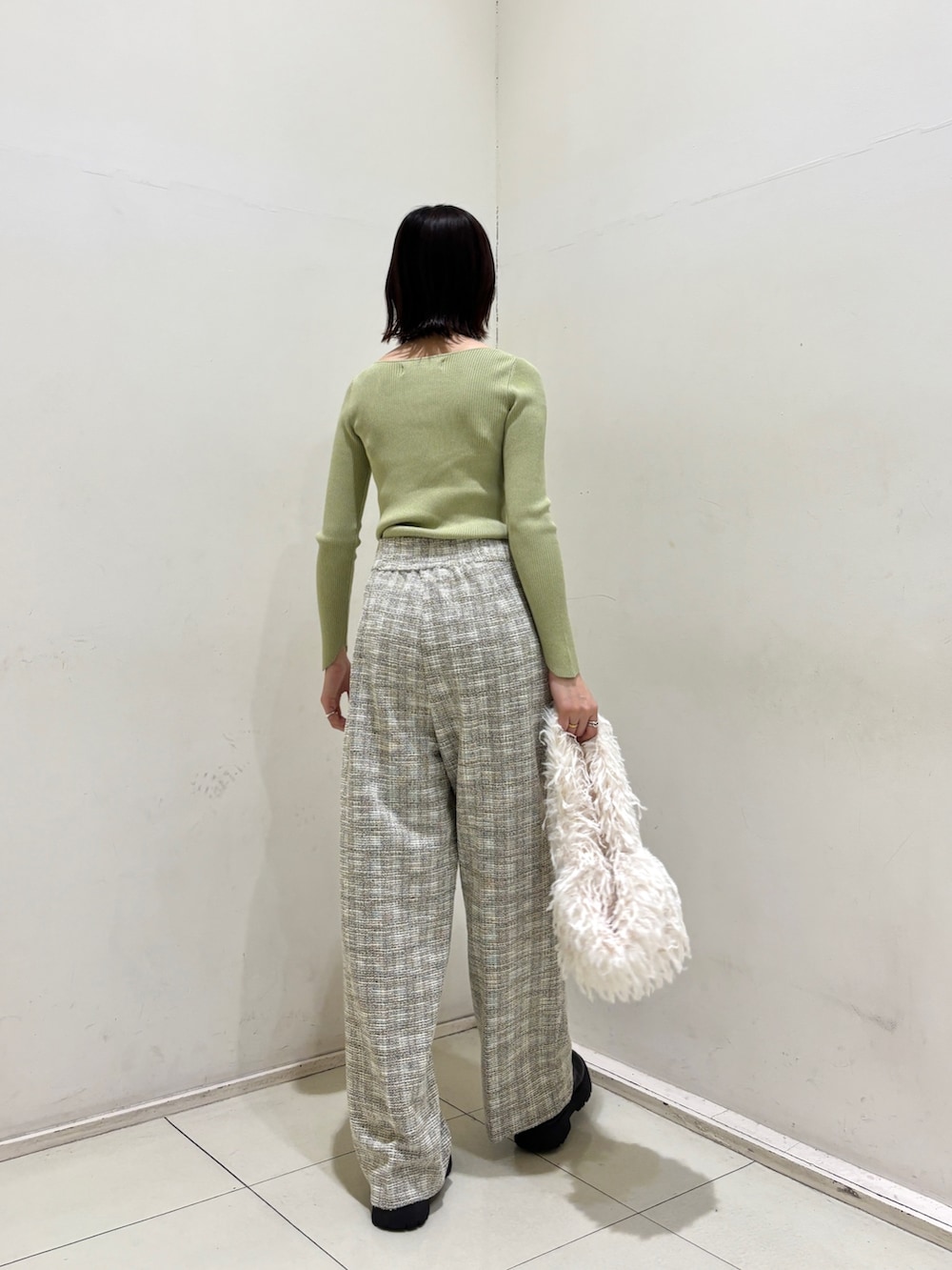 ホワイト系のその他パンツ、グリーン系のニット/セーター、ホワイト系のハンドバッグを着用したレディースの冬コーディネートの4枚目の写真