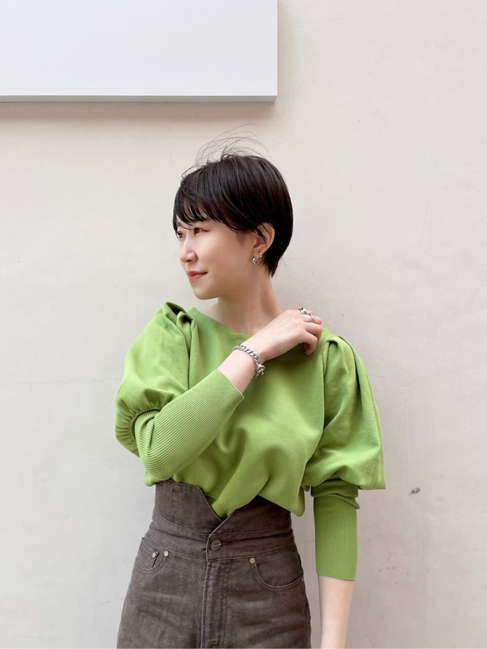 ブラック系のその他シューズ、ブラック系のハンドバッグ、グリーン系のニット/セーターを着用したレディースの冬コーディネートの6枚目の写真