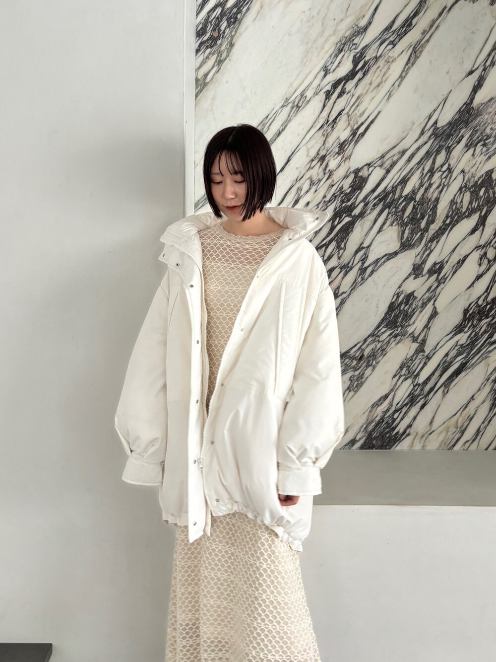 ホワイト系のワンピース、シルバー系のブーツ、ホワイト系のダウンジャケット/コートを着用したレディースの秋コーディネートの7枚目の写真